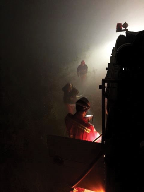 Roberts Creek crew control hot spots during a night shift after a fire passed through.
