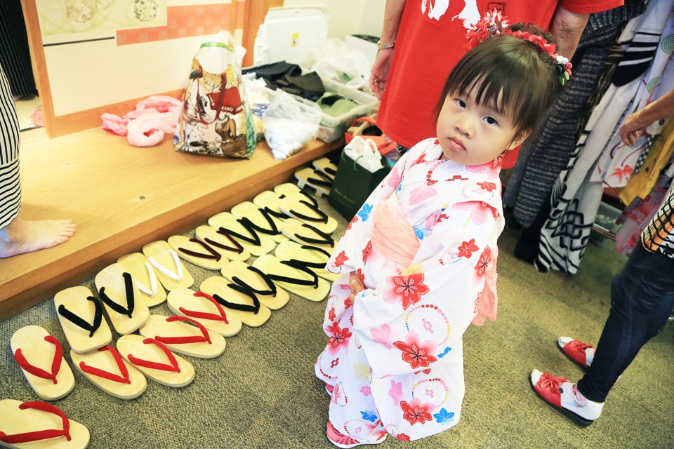 Three-year-old Amber Du tries on a kimono in the kimono dressing area.