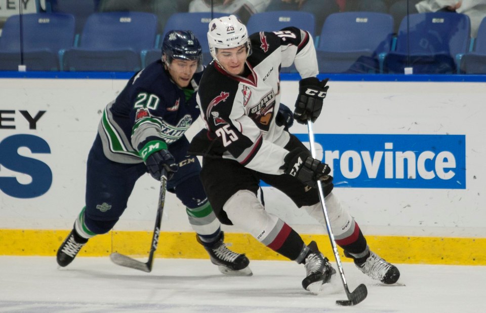 Kaleb Bulych fights off a check while carrying the puck for the Vancouver Giants