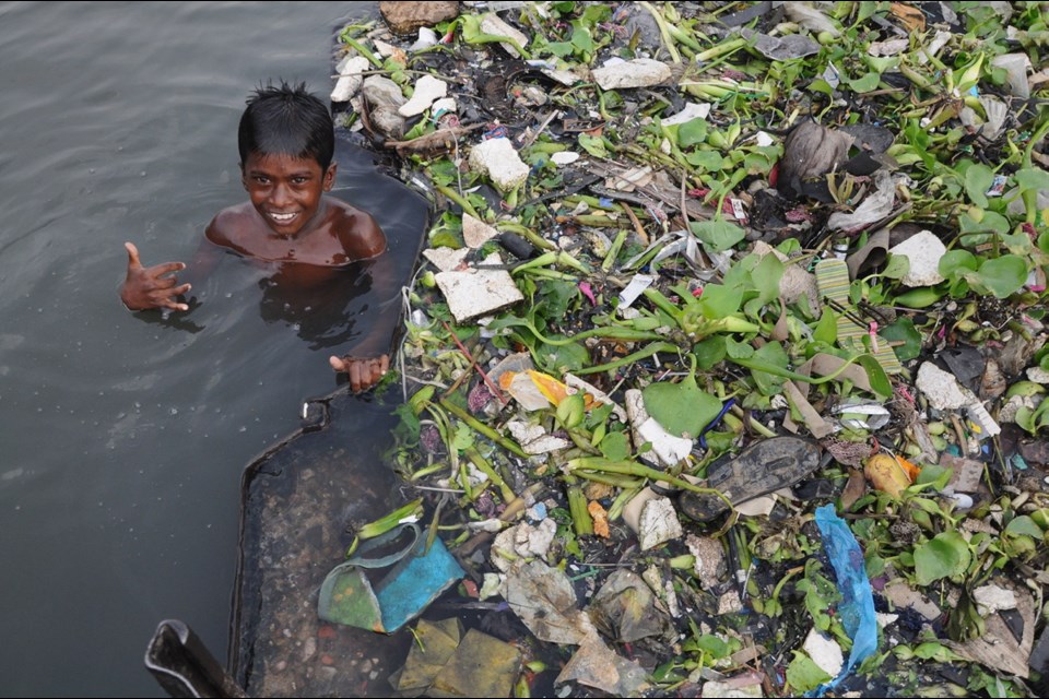 A young boy plays among plastic and garbage in the Buriganga River in Dhaka, Bangladesh. Some of the plastics that are found in Asian rivers might have come from Canada, Monique Keiran writes.