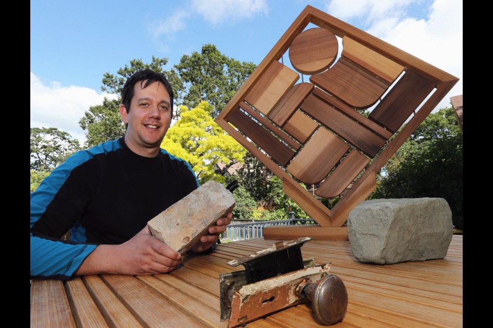 Artist Carey Newman with a few of the artifacts from residential schools that he turned into a larger version of the model artwork behind him, the Witness Blanket sculpture. Newman&Otilde;s new work, Earth Drums, has been selected as the winner of Saanich's 150 public art competition.