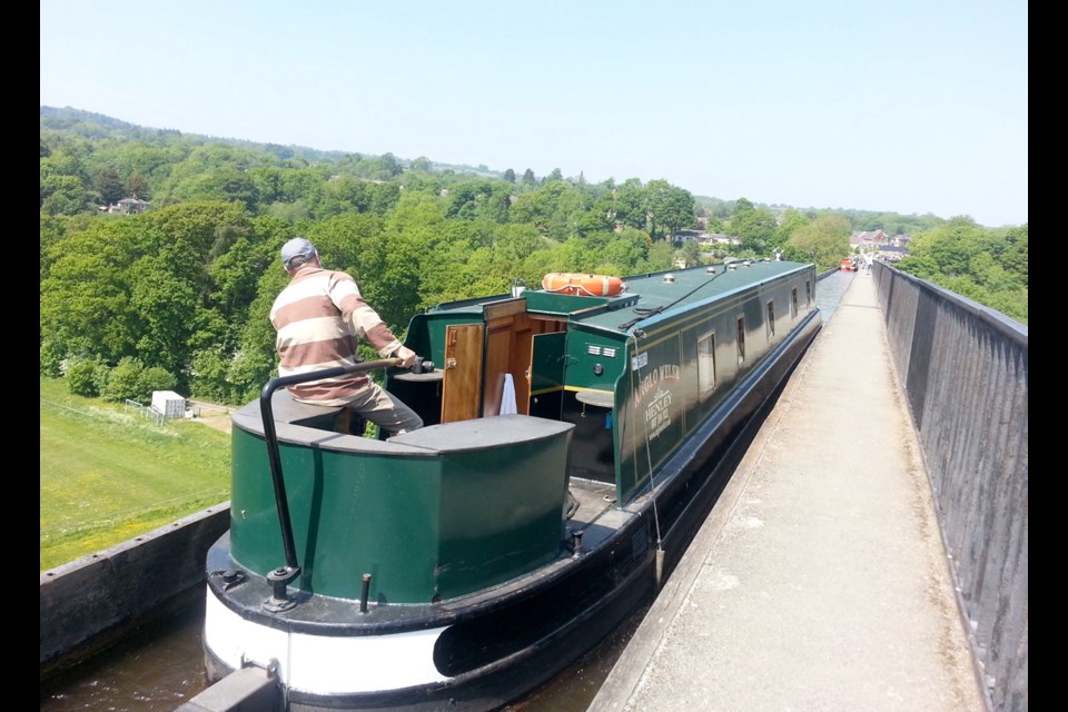 Mark Reuten keeps a watchful eye at the tiller as the canal boat crosses the stunning Pontcysyllte Aquaduct in North Wales at the end of a two-week journey.