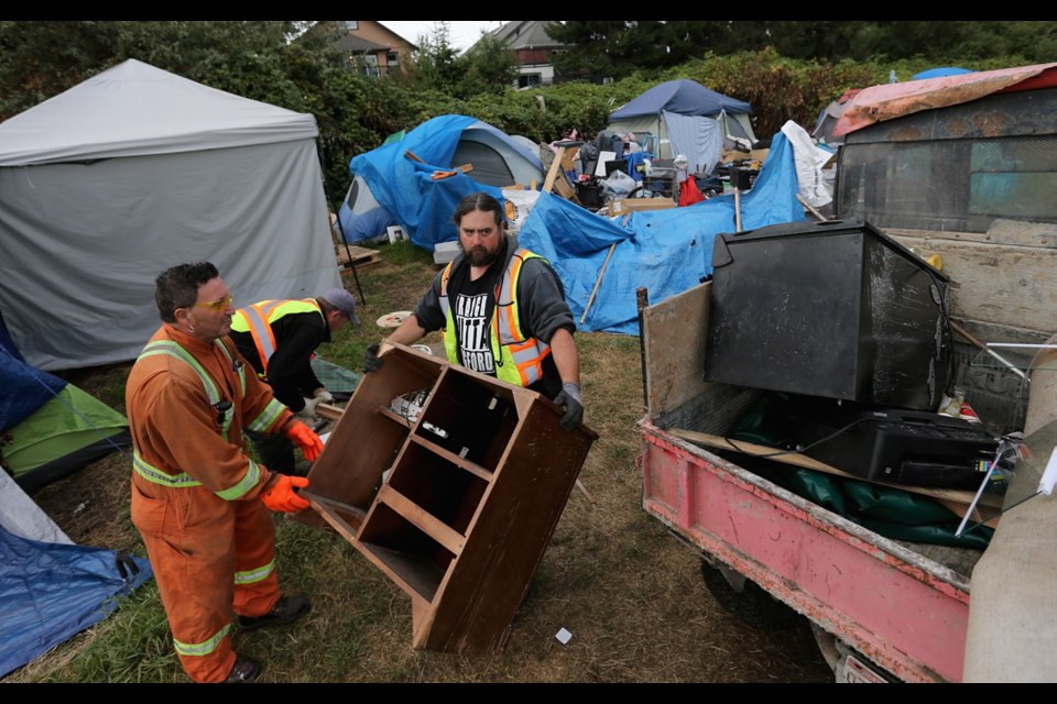Crew removes items from the tent city at Regina Park on Wednesday.