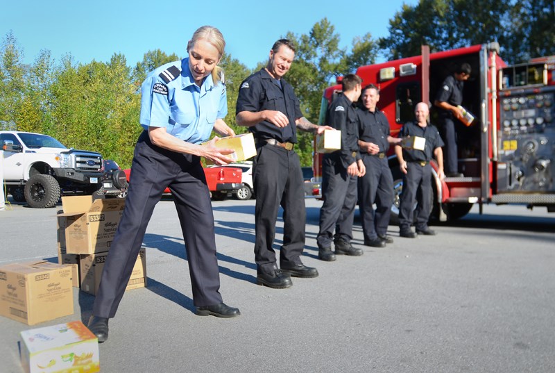 Burnaby firefighters line up to load boxes of food into a truck at Fire Hall 1 earlier this month. Paid for by the Burnaby Firefighters Charitable Society, the snacks are bound for local schools.