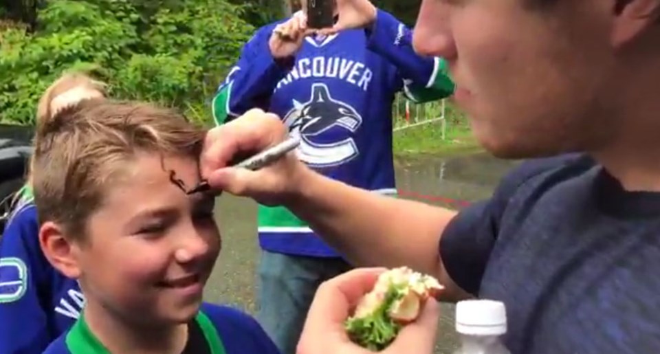 Canucks fan get forehead signed