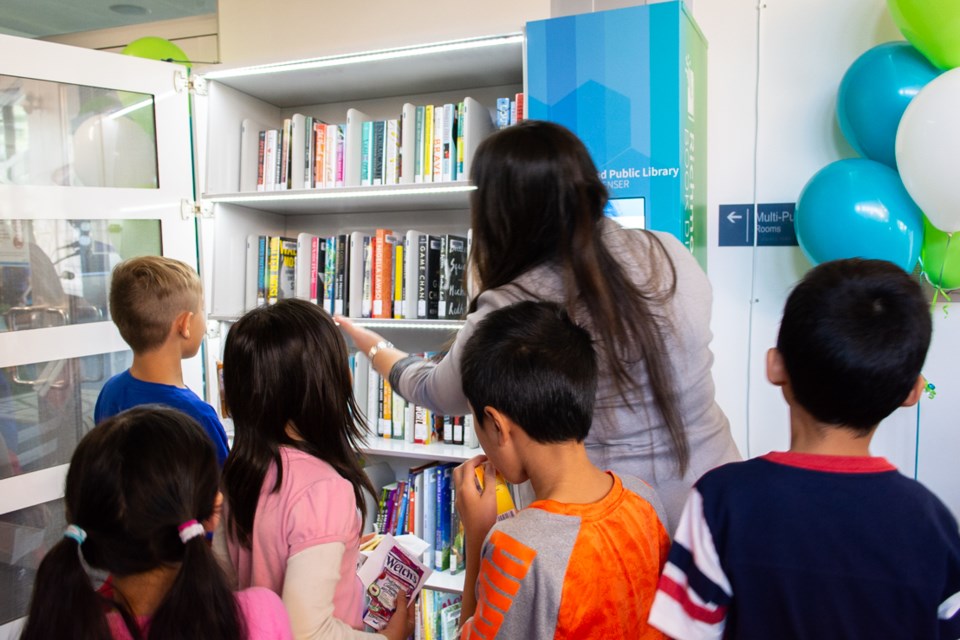 Library staff member showing students how the dispenser works. Photo: Submitted