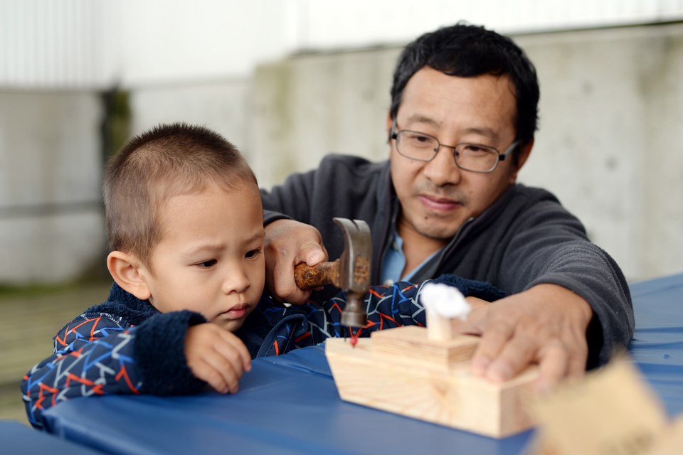 Rueson He makes a boat with help from dad Lou He at RiverFest.