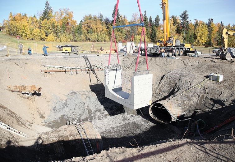 Part of a concrete chamber is put in place Thursday as part of the effort to put an end to the sinkhole on Winnipeg Street. It will replace eight-metres of deteriorated metal pipe.