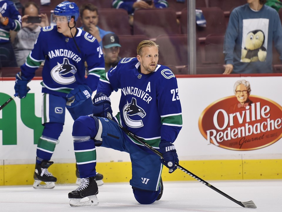 Alex Edler takes a knee during warmup for a preseason game with the Canucks.