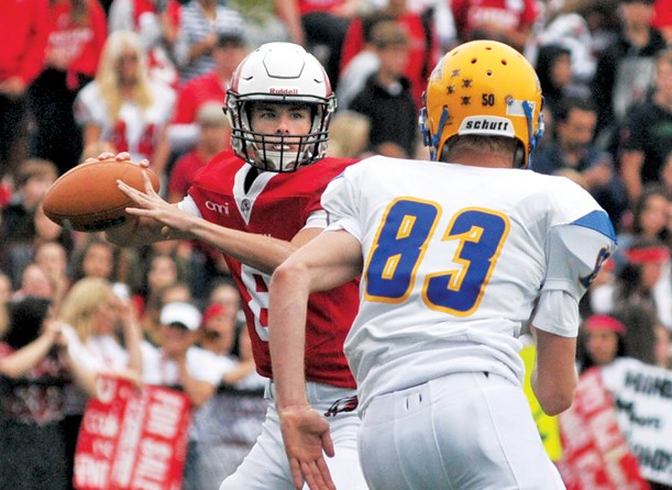 Carson Graham quarterback Charlie McMillan looks to make a play under pressure as Handsworth's Bowen Drzymala-Bokitch closes in during the Buchanan Bowl played Saturday at Carson. photo Paul McGrath, North Shore News