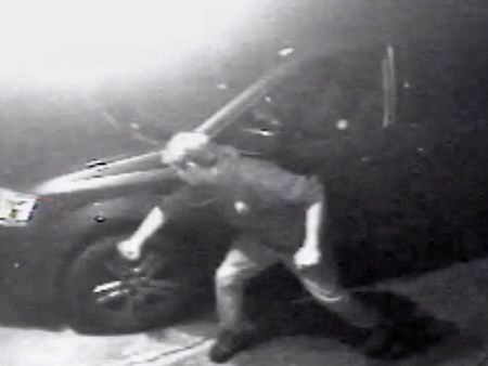 A tire-slashing suspect is caught in the act in an image taken from security video footage obtained by Burnaby RCMP.