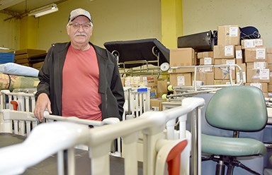 Dan Gallant of Port Moody stands amongst some of the items, including specialized cribs recently donated by BC Children's Hospital, at the Rotary World Help warehouse at the Riverview Lands in Coquitlam.