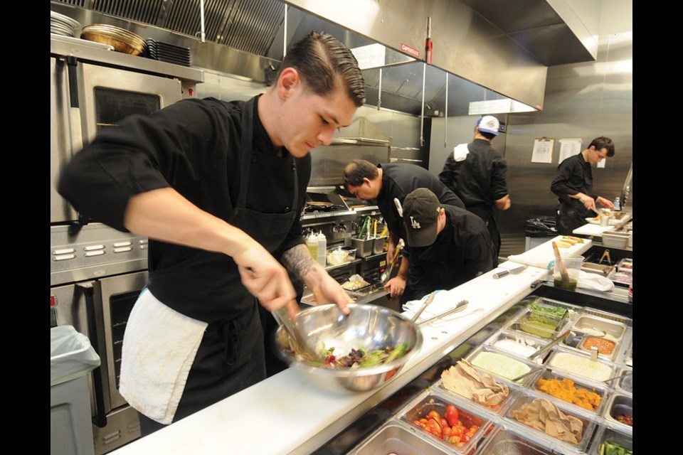 Sous chef Marcus Evan puts together a house salad in the very busy kitchen at Colony Northwoods.