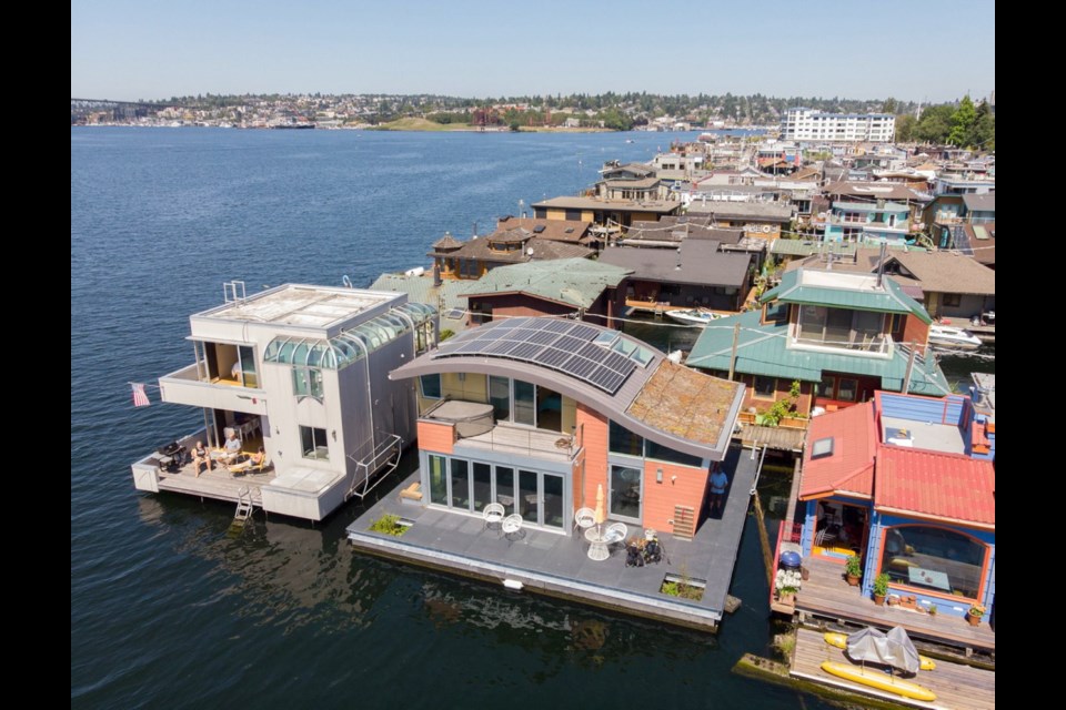 Architect Michelle Lanker; her husband, Bill Bloxom; and their doggies Bing and Arnie live on the second floating home from the left &Ntilde; the one with the distinctive, and distinctively sustainable, curved roofline, solar panels and vegetated roof system. G. Little Construction built the LEED Platinum-certified home in Port Townsend before it was towed to Lake Union