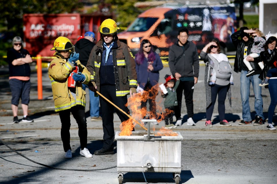 Elaine Soo takes part in a demonstration with fire inspector Dylan Murray.