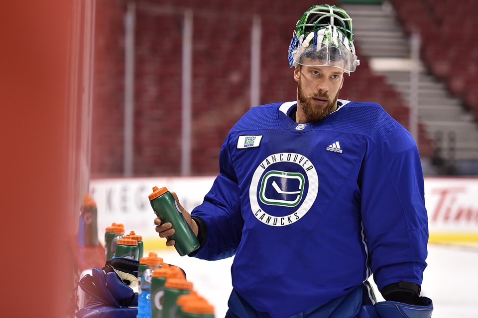 Anders Nilsson grabs his water bottle during Canucks practice