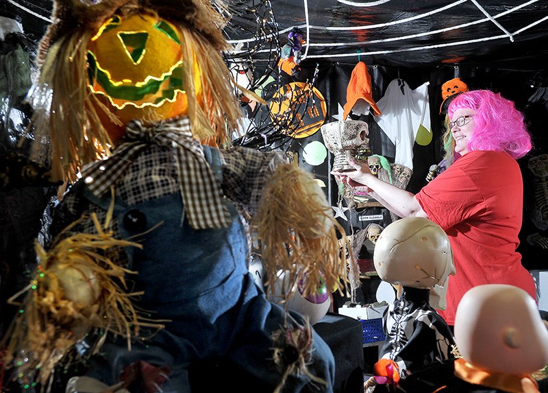 Vickie Ayers looks for the perfect spot to add another spooky decoration outside her family's home at 443 Draycott St. in Coquitlam. The family has been decorating their home for Halloween for 19 years to raise money for Variety - The Children's Charity. The display officially opens to visitors on Saturday.