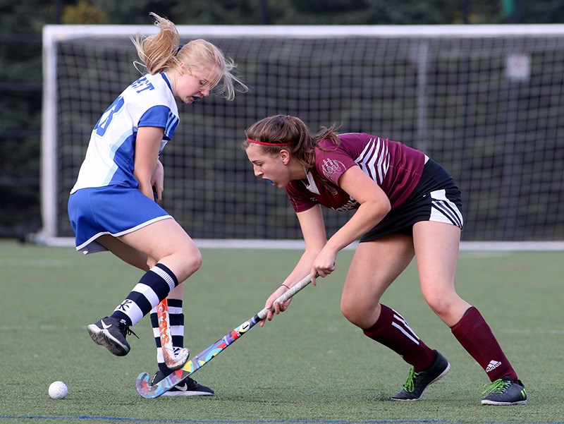 MARIO BARTEL/THE TRI-CITY NEWS
Heritage Woods Kodiaks forward Gina Henney battles to get the ball past Dr. Charles Best Blue Devils defender Masha Ristau in the first half of their senior girls field hockey district final, Wednesday at Town Centre Park in Coquitlam. Heritage Woods won the match, 2-0, with both goals coming in the second half. It's the first district championship for the Port Moody school since 2011. The win also preserved the Kodiaks' undefeated record as they finished the season with seven wins and two draws. Both distict finalists, as well as third place finisher Centennial secondary and fourth place Gleneagle Talons, advance to the Fraser Valley championships which begin on Monday at Tamanawis Fields in Surrey.