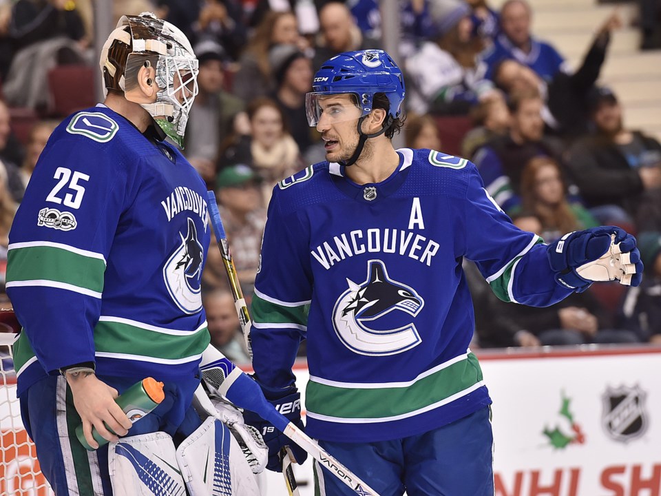 Michael Del Zotto talks to Jacob Markstrom during a break in play