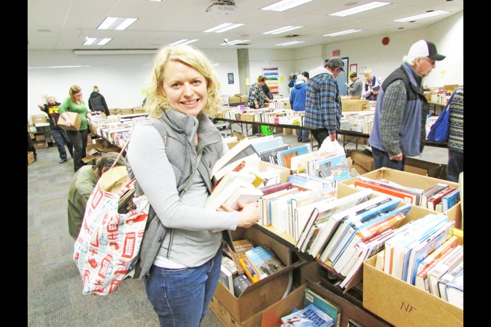 Cynthia Branigan, elementary school teacher, made her choices during the Friends of the Library Society book sale held Saturday at the main branch of the library.The fundraising event is held twice a year. Citizen photo by Christine Hinzmann