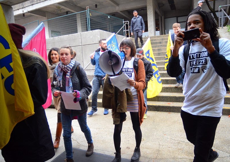 A group of SFU students protesting proposed tuition hikes next year marches into a student budget consultation at the Burnaby Mountain campus Tuesday morning.
