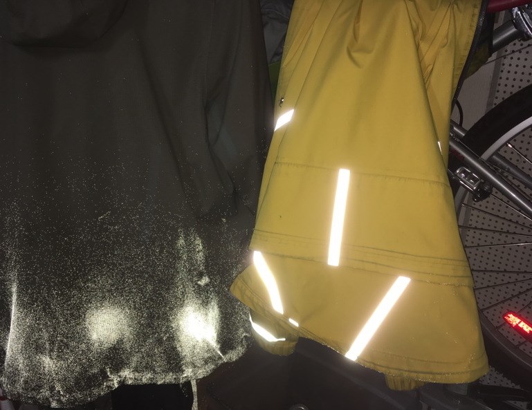Reflective jackets in the dark, photographed with a flash. The jacket on the left was sprayed with a reflective material that is mostly invisible in daylight.