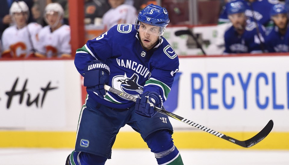 Derrick Pouliot passes the puck up ice for the Vancouver Canucks