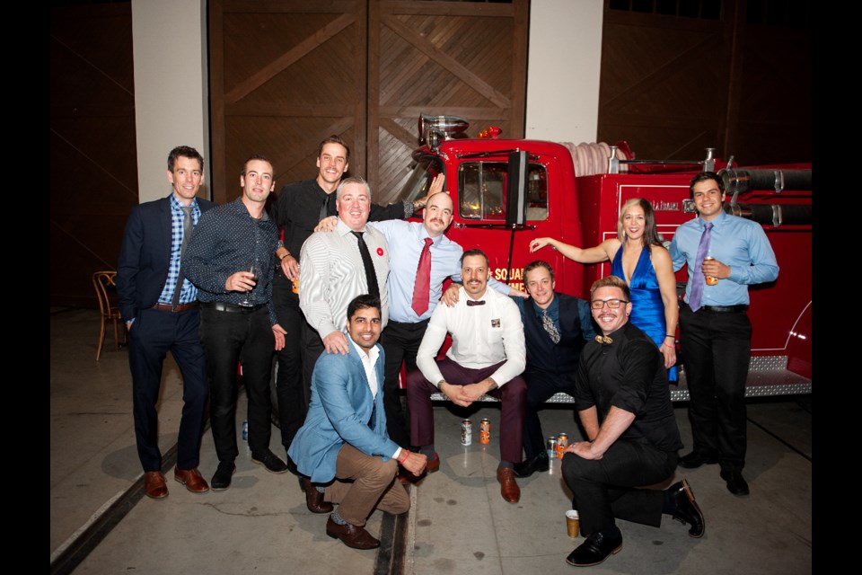 A group of firefighters at the Firefighter's Ball gather around Squamish's first fire truck, which was purchased in 1956.
