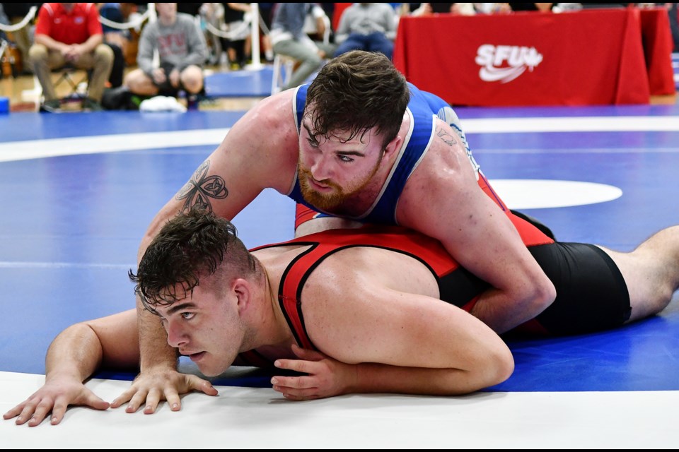 Simon Fraser University’s Ciaran Ball, at top, tries to pin down Regina’s Jordan Tholl during the first of two encounters at Saturday’s SFU Open in the men’s 125-kilogram division. They would meet in the third-place match, with Ball emerging victorious after a 9-1 decision.