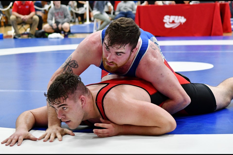 Simon Fraser University’s Ciaran Ball, at top, tries to pin down Regina’s Jordan Tholl during the first of two encounters at Saturday’s SFU Open in the men’s 125-kilogram division. They would meet in the third-place match, with Ball emerging victorious after a 9-1 decision.