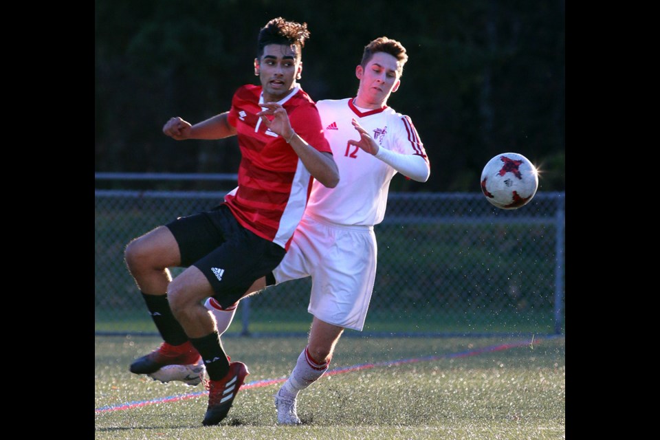 MARIO BARTEL/THE TRI-CITY NEWS
Matthew Garofalo of the Terry Fox Ravens battles an Abbotsford player for the ball in the first half of their Fraser Valley Secondary Schools Soccer Commission semifinal match, Tuesday at Port Coquitlam's Gates Park. Abbotsford won the match, 1-0.