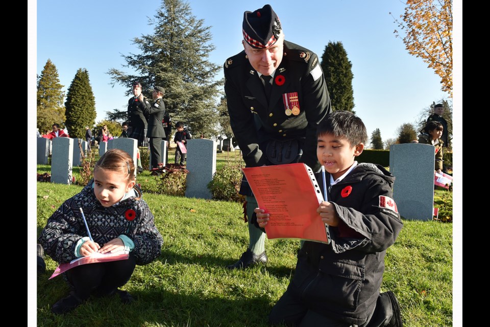 St.Mary's students Mikaela Ferreira and Lorenzo Ronque speak with Seaforth Highlanders member Major Steve McNally during Wednesday's No Stone Left Alone ceremony at Mountain View cemetery.