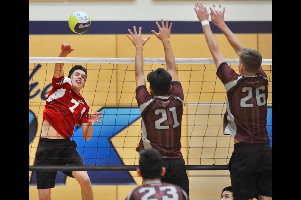 Richmond Christian's Jackson Campbell hits past a pair of Richmond Colt blockers during Wednesday's Richmond Senior Boys Volleyball championship match at Steveston-London. The Eagles are champions for the second straight year, capping another unbeaten run with a3-0 win.