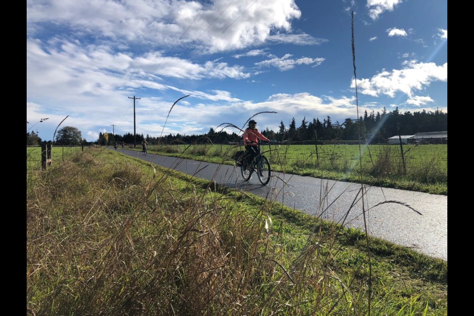 Cate Coppard-Reuten cycles through a farming area on the portion of the Olympic Discovery Trail between Port Angeles and Sequim.