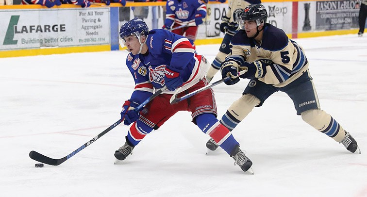 Spruce Kings winger Patrick Cozzi gets set to shoot whille being checked by Langley Rivermen defenceman Garrett Daly during BCHL action Saturday at RMCA. The Rivermen left with a 2-1 victory.