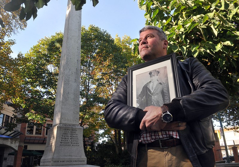 John Goheen of Port Coquitlam stands in front of the PoCo cenotaph holding a picture of his maternal grandfather who fought in the First World War.
