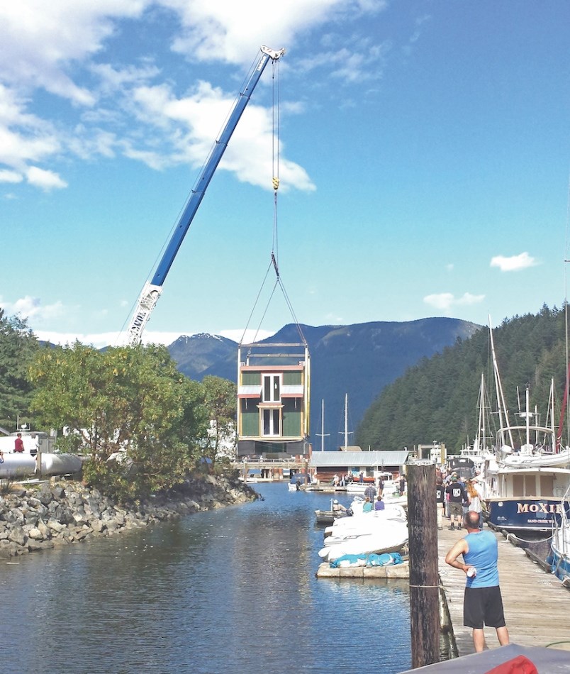 Floating home being lowered into the water.