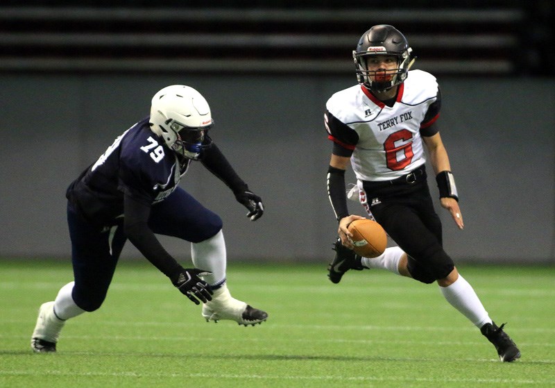 MARIO BARTEL/THE TRI-CITY NEWS
Terry Fox Ravens Grade 10 quarterback Key'Shaun Dorsey scrambles away from a Notre Dame tackler in the first half of their BC Secondary Schools Football Association Subway Bowl quarter-final, Saturday at BC Place stadium. The Ravens won the game, 35-21, setting up a rematch with the New Westminster Hyacks, the team that beat them in the last second of last year's final.