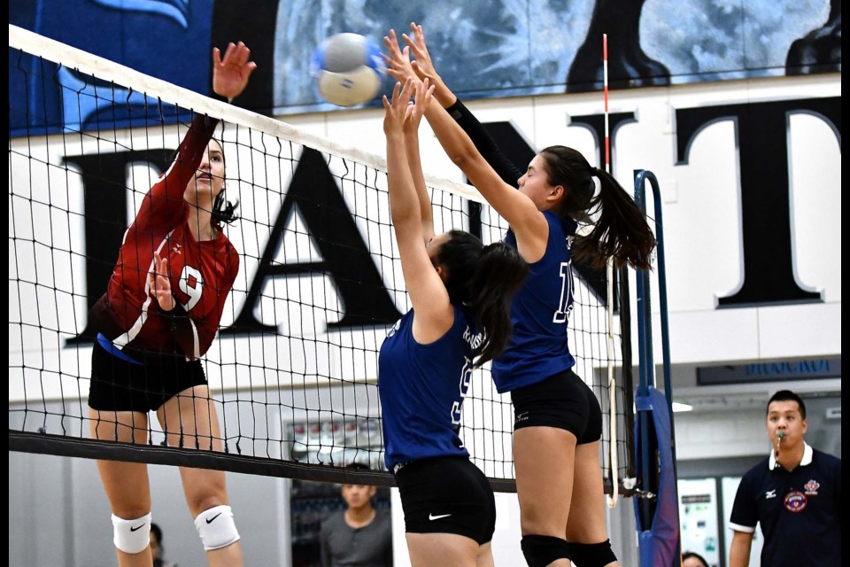 Playing a strong net game, Moscrop senior Panthers' Madeleine Richardson, left, and Alana Leung put their hands up to block junior national team member and Lord Byng power Katarina Pantovic during Saturday's Lower Mainland championship final.