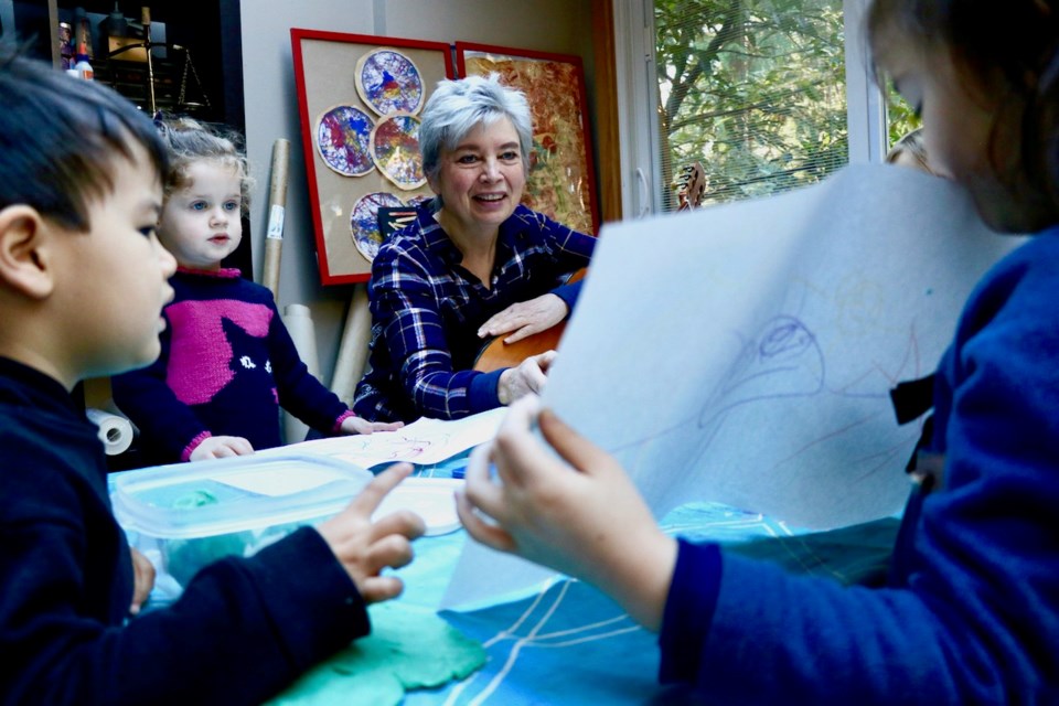 Elisabeth Mueller admires one of her charges’ drawings at the daycare she operates out of her home.