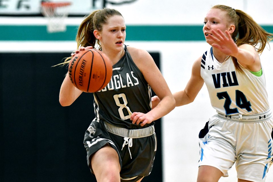 Douglas College’s Sydney Fraess, at left, moves past Vancouver Island’s Olivia Mjaaland during a recent PacWest league game. Douglas entered the holiday break on a two-game winning streak, beating Capilano University 73-68 and Okanagan College 67-57 last weekend.
