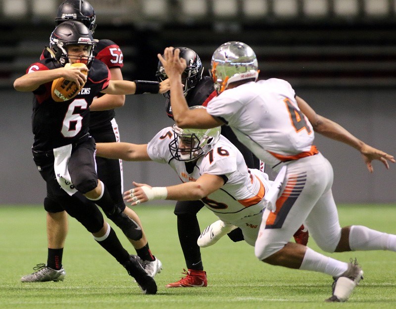 MARIO BARTEL/THE TRI-CITY NEWS Terry Fox Ravens quarterback Key'Shaun Dorsey tries to escape from New Westminster Hyacks tacklers Kinsale Phillip and Evan Nolli in their BC Secondary Schools Football Association AAA semi-final, Saturday at BC Place Stadium. New Westminster won the game, 33-0.