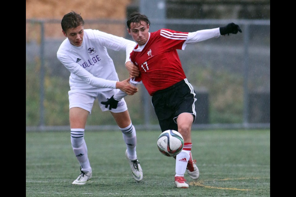 MARIO BARTEL/THE TRI-CITY NEWS
Terry Fox Ravens Nico Borella battles his way past a Vancouver College defender in the first half of their second round match at last week's B.C. Secondary Schools Soccer Commission AAA provincial finals, held at the Burnaby Lake Sports Complex West. Fox lost the match, 2-0. Vancouver College went on to win the championship, beating Surrey’s Panorama Ridge 2-0 in the final. Fox finished seventh after they defeated Oak Bay 2-0 in their final match. Defending champion Dr. Charles Best Blue Devils finished the tournament in fifth place with a 3-0 win over Burnaby Mountain in their placement match. The Heritage Woods Kodiaks were in 10th place after a 3-2 loss in penalty kicks to Robert A. McMath from Richmond on Saturday.