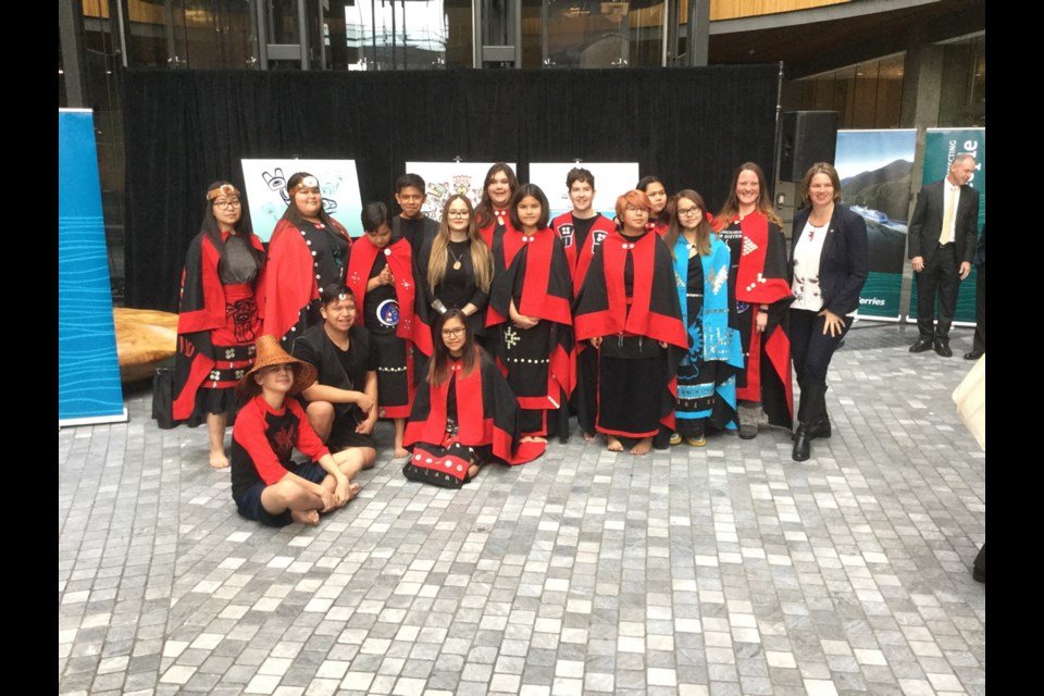 Nuxalk Nation dancers with Indigenous artist Danika Naccarella, centre, with glasses, and North Coast MLA Jennifer Rice, far right.