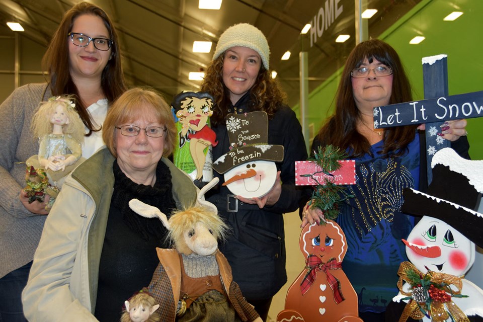 The organizers of the 38th annual Coquitlam Christmas Craft Fair, Julie Zado and Tabitha McLoughlin, with Coquitlam vendors Pam Leitch (sitting) and Nicola Lafortune (right). The fair opens Friday and includes 110 sellers of jewelry, knitting and pottery.