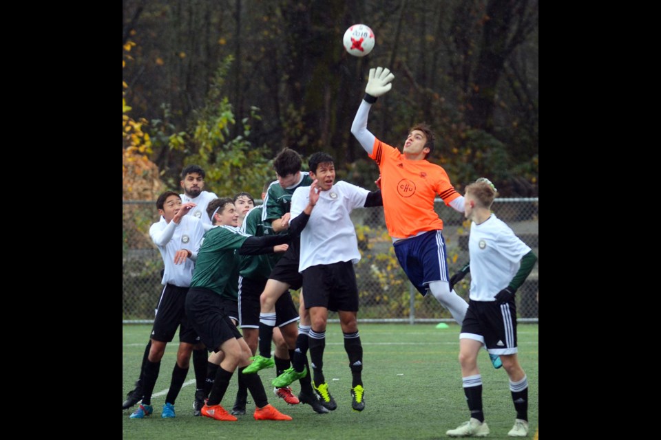 Burnaby Mountain goalkeeper Gustavo Halfen Simon gets ready to make a save while teammates Nic Riccardi, Liam Atterton, Tim Ellen and Maks Boyle, in green, and players from Abbotsford crowd the box during last Friday’s game at the AAA provincial soccer championships.