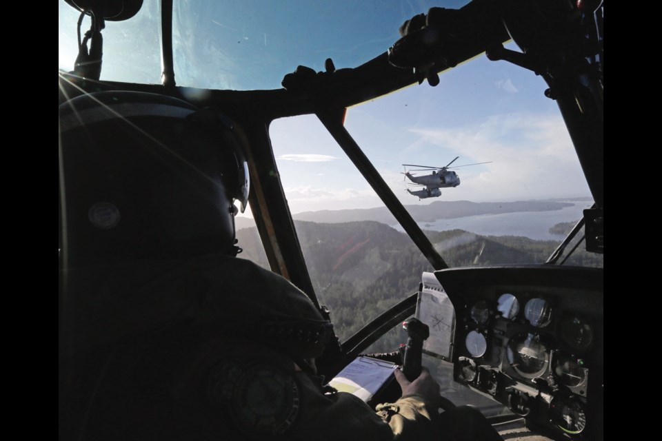 Capt. Evan MacDonald flies beside two other Sea King helicopters during an exercise over the lower Island last week.