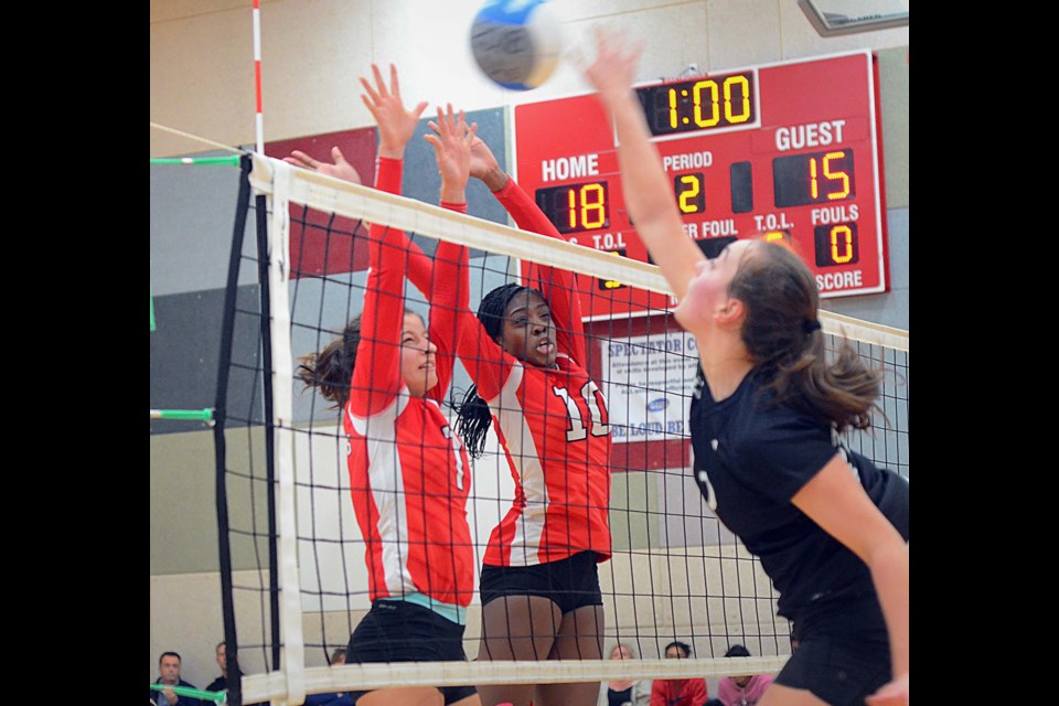 St. Thomas More’s Giulianna Gaspar and Ezawa Malish go for the block on the Langley Christian attackers during last Thursday’s action at the AA senior girls volleyball championships, hosted by STM.
