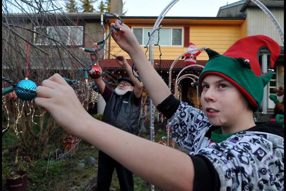 Gabriel Hyvarinen Bentzen helps his grandfather, Digby Bentzen, set up the family's Christmas light display at their home on Paula Place in Port Coquitlam.