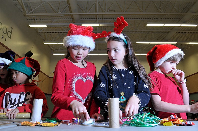MARIO BARTEL/THE TRI-CITY NEWS
Madison Shung, 9, and Ava Vagarelli, 9, set up their work stations in the gym at Aspenwood elementary school where Grade 4/5 students crafted Christmas crackers for local seniors homes.